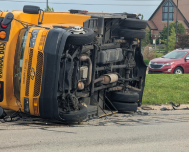 Staffer, other driver injured after crash causes school bus to roll
